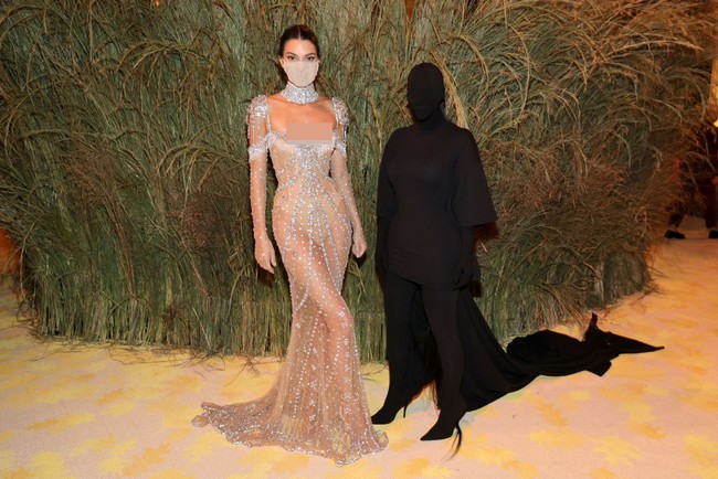 Selain penampilannya yang memesona dengan gaun menerawang Givenchy, momen Kendall Jenner berpose dengan Kim Kardashian ini juga viral. Kim yang memakai busana hitam menutupi seluruh tubuh termasuk wajah viral jadi meme disebut khodam alias jin saat berpose di samping Kendall. Foto: Mike Coppola/Getty Images
