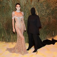 Selain penampilannya yang memesona dengan gaun menerawang Givenchy, momen Kendall Jenner berpose dengan Kim Kardashian ini juga viral. Kim yang memakai busana hitam menutupi seluruh tubuh termasuk wajah viral jadi meme disebut khodam alias jin saat berpose di samping Kendall. Foto: Mike Coppola/Getty Images