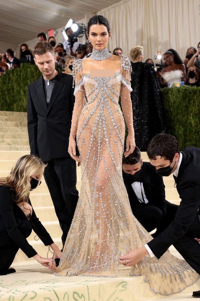 Inilah foto yang jarang terekpos di mana momen Kendall Jenner dibantu oleh para usher Met Gala 2021 untuk tampil paripurna saat berpose di depan juru foto. Foto: Mike Coppola/Getty Images