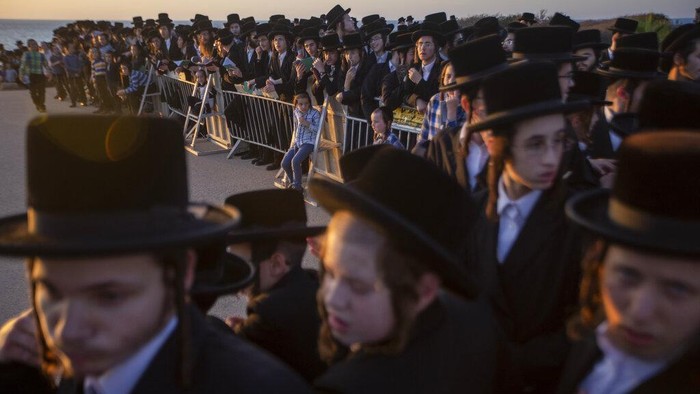 Menengok Ritual Pembersihan Dosa di Tahun Baru Yahudi Ultra-Orthodox Jews of the Kiryat Sanz Hassidic sect listen to their rabbi on a hill overlooking the Mediterranean Sea as they participate in a Tashlich ceremony, in Netanya, Israel, Tuesday, Sept. 14, 2021. Tashlich, which means