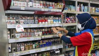 Pekerja merapikan rokok di salah satu Minimarket kawasan Jakarta Selatan, Rabu (15/4/2021). 