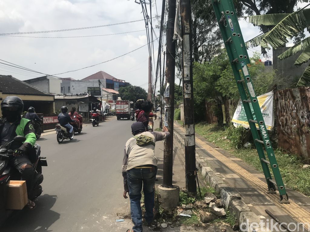 Tiang dicabut dan dipindahkan dari badan Jl WR Supratman, Ciputat Timur, Tangsel, 15 September 2021. (Faiz Iqbal Maulid/detikcom)