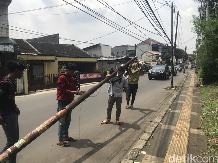 Tiang dicabut dan dipindahkan dari badan Jl WR Supratman, Ciputat Timur, Tangsel, 15 September 2021. (Faiz Iqbal Maulid/detikcom)