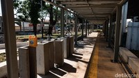 Tumpukan tanah, batu, pasir, dan bahan bangunan lainnya berjejer di lokasi.