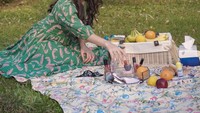 Raisa tampil cantik dengan gaun hijau sambil piknik di pekarangan rumahnya. Ia membawa beragam buah-buahan segar, ada pisang hingga jeruk sunkist. Foto: Instagram @raisa6690