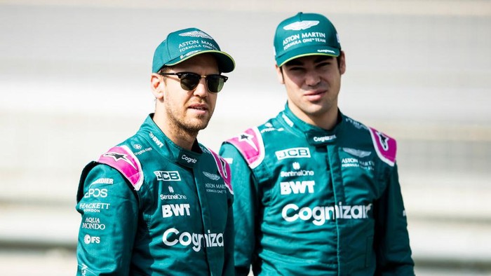 BAHRAIN, BAHRAIN - MARCH 12: Sebastian Vettel of Germany and Aston Martin F1 Team and Lance Stroll of Canada and Aston Martin F1 Team look on as they stand on the grid during Day One of F1 Testing at Bahrain International Circuit on March 12, 2021 in Bahrain, Bahrain. (Photo by Mark Thompson/Getty Images)