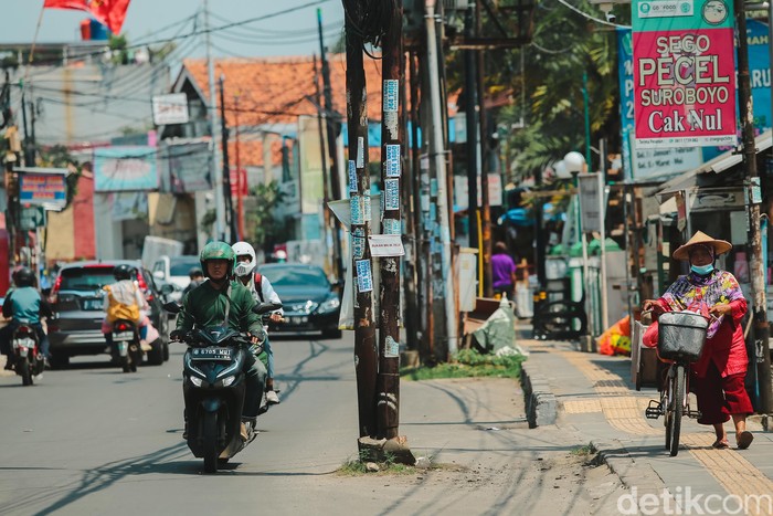 Sejumlah tiang yang berdiri di badang jalan WR Supratman, Ciputat Timur, Tangerang Selatan, masih berdiri tegak, Jumat (17/9/2021). Belasan tiang masih berdiri memakan badan jalan di Ciputat Timur. Padahal, tiang-tiang utilitas itu harus sudah dipindahkan sebelum 20 September 2021.