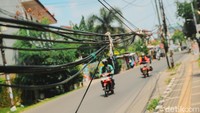 Sejumlah tiang yang berdiri di badang jalan WR Supratman, Ciputat Timur, Tangerang Selatan, masih berdiri tegak, Jumat (17/9/2021). Belasan tiang masih berdiri memakan badan jalan di Ciputat Timur. Padahal, tiang-tiang utilitas itu harus sudah dipindahkan sebelum 20 September 2021.  