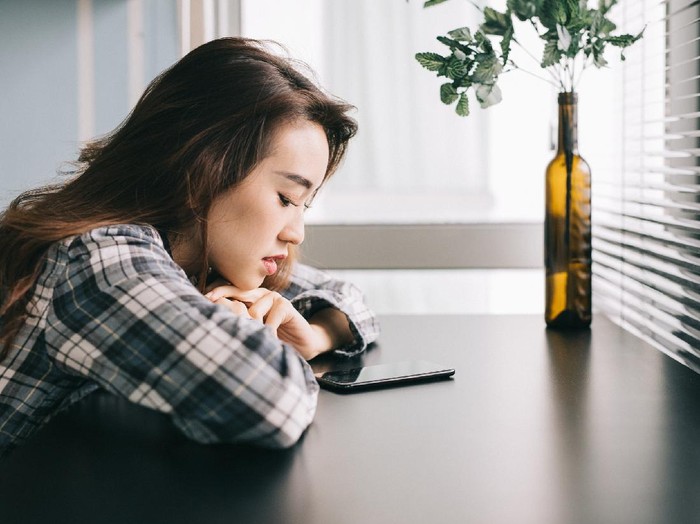 Young woman with smartphone waiting for a text from her friend