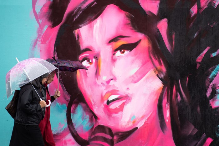 Mural Amy Winehouse di Inggris LONDON, ENGLAND - SEPTEMBER 14: (L-R) Exhibition curator Priya Khanchandani and Naomi Parry attend a mural unveiling to mark the Design Museum's Amy Winehouse exhibition announcement in Camden on September 14, 2021 in London, England. (Photo by Jeff Spicer/Getty Images)