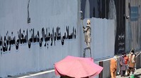 Taliban mengecatnya menjadi warna putih dan mengganti mural dengan tulisan Arab serta gambar pemimpin mereka. Foto: AFP/AAMIR QURESHI