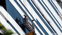 Sejumlah petugas membersihkan kaca gedung di kawasan Jalan TB Simatupang, Jakarta Selatan, Jumat (17/9/2021).