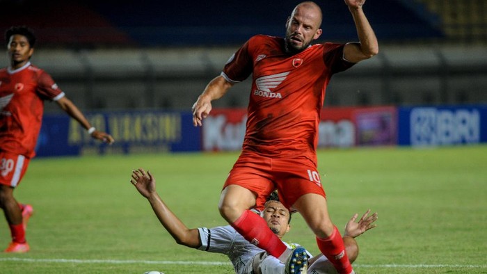 Pesepakbola PSM Makasar Anco Jansen (kanan) dihadang  pesepakbola Persebaya Surabaya Arif Satria (kiri) saat berlaga pada lanjutan BRI Liga 1 antara PSM Makasar melawan Persebaya Surabaya di Stadion Si Jalak Harupat, Kabupaten Bandung, Jawa Barat, Sabtu (18/9/2021). Pada babak pertama, PSM Makasar unggul dengan skor 3-1. ANTARA FOTO/Raisan Al Farisi/hp.