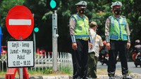 Polisi berjaga di area masuk menuju TMII untuk menyeleksi kendaraan sesuai aturan ganjil-genap.