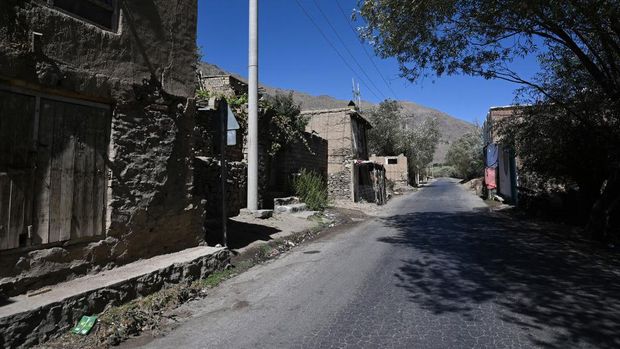 Taliban fighters walk past ammunition along a road in Malaspa area, Bazark district, Panjshir Province on September 15, 2021, days after the hardline Islamist group announced the capture of the last province resisting to their rule. - Under late Afghan commander Ahmad Shah Massoud, the Panjshir fighters earned a legendary reputation for resistance, defending their mountain homes first from the Soviet military for a decade, then throughout a civil war, then the last Taliban regime from 1996-2001. (Photo by WAKIL KOHSAR / AFP)