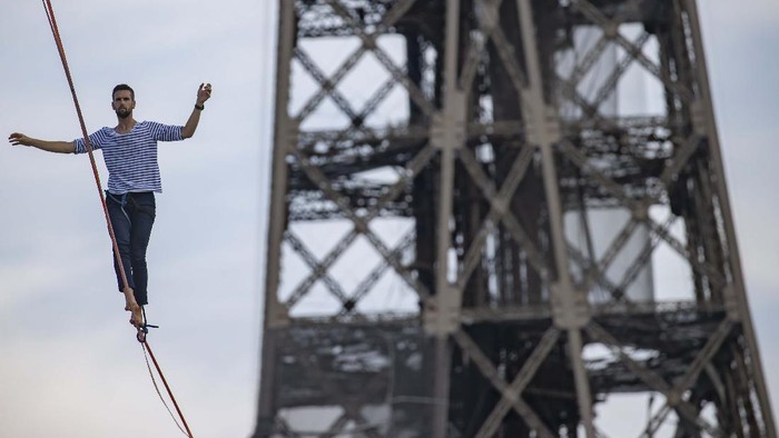 (210918) -- PARIS, 18 September, 2021 (Xinhua) -- Akrobatik Prancis Nathan Paulin meniti seutas tali slackline yang dipasang pada ketinggian 70 meter dan membentang sepanjang 670 meter di antara Menara Eiffel dan Theater National de Chaillot di Paris, Prancis, pada 18 September 2021. (Xinhua)