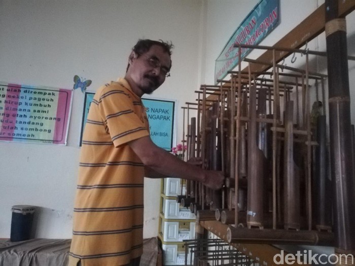 Bambang Samsudin tengah memainkan angklung bernada diatonis di studio miliknya
