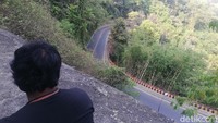 Warga tampak asik memandangi panorama alam Cadas Pangeran lengkap dengan pemandangan jalan yang berkelok-kelok di Jalan Cadas Pangeran bagian atas.