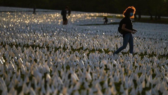 Zoe Nassimoff, of Argentina, looks at white flags that are part of artist Suzanne Brennan Firstenberg's temporary art installation, 