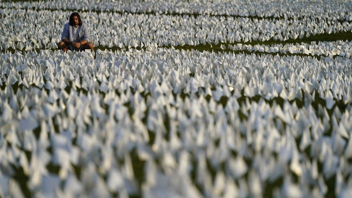 Zoe Nassimoff, of Argentina, looks at white flags that are part of artist Suzanne Brennan Firstenberg's temporary art installation, 