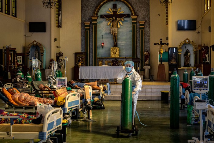 1336229121 MANILA, PHILIPPINES - AUGUST 25: A healthcare worker moves an oxygen tank as patients infected with Covid-19 are treated at a chapel converted into a Covid-19 intensive care unit on August 25, 2021 in Quezon city, Metro Manila, Philippines. Hospitals in the Philippines are running out of beds for Covid-19 patients as the country struggles to cope with a huge wave of cases fueled by the more infectious Delta variant. Recording more than 1.8 million cases and more than 32,000 deaths, the Philippines continues to suffer the second-worst outbreak of the pandemic in Southeast Asia, with every one out of four people tested turning out positive for the coronavirus. (Photo by Ezra Acayan/Getty Images)