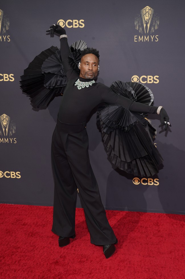 Bukan Billy Porter namanya jika tidak membawa drama ke karpet merah. Untuk Emmy Awards 2021, aktor ‘Pose’ itu mengandalkan busana serba hitam dari Ashi Studio. Atasan lengan panjangnya dilengkapi semacam sayap berbentuk kipas, berikut statement necklace dari Lorraine Schwartz. (Foto: Chris Pizzello/Invision/AP/Chris Pizzello)