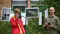 Ini adalah duo fotografer asal Glasgow, Skotlandia, Brian Hartley dan Dyan Lombard sedang berpose di depan pameran fotografinya. Foto: Getty Images/Jeff J Mitchell