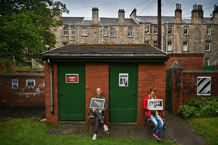 GLASGOW, SCOTLAND - SEPTEMBER 17: Brian Hartley and Dylan Lombard (R) pose beside their photographic exhibition in a tenement garden on September 17, 2021 in Glasgow, Scotland. “Stills of a Lockdown City” features images taken during the 2020 coronavirus lockdown by Glasgow-based artist Brian Hartley and 18-year-old Dylan Lombard, and aims to offer “a perspective that allows us to make more sense of the world”. It will take place on September 18 and 19, 2021. (Photo by Jeff J Mitchell/Getty Images)