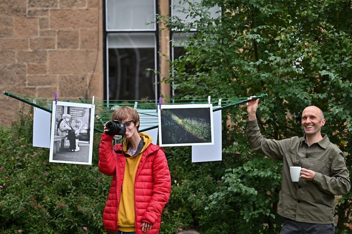 GLASGOW, SCOTLAND - SEPTEMBER 17: Brian Hartley and Dylan Lombard (R) pose beside their photographic exhibition in a tenement garden on September 17, 2021 in Glasgow, Scotland. “Stills of a Lockdown City” features images taken during the 2020 coronavirus lockdown by Glasgow-based artist Brian Hartley and 18-year-old Dylan Lombard, and aims to offer “a perspective that allows us to make more sense of the world”. It will take place on September 18 and 19, 2021. (Photo by Jeff J Mitchell/Getty Images)