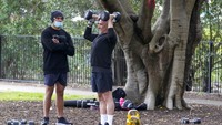 Tampak warga tengah latihan angkat beban mengangkat barbel dipantau oleh seorang personal trainer di Taman Waterfront yang berada di kawasan Sydney, Australia.