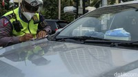 Petugas kepolisian melakukan penindakan dengan menerbitkan surat bukti pelanggaran (tilang) kepada pengendara yang menyalahi peraturan, seperti terlihat di Bundaran HI, Jakarta, Senin (20/9/2021).