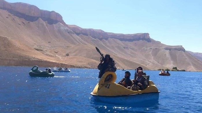 Petempur Taliban naik perahu bebek sambil menenteng senjata (Twitter/@Jake_Hanrahan)