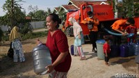 Seorang warga terlihat sangat semringah usaimendapatkan air bersih.