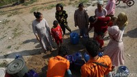 Mereka menampung air ke dalam jerigen.
