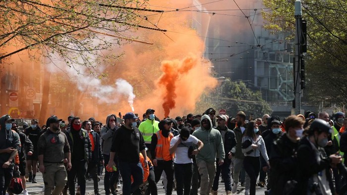 Flares are lit as construction workers and demonstrators attend a protest against Covid-19 regulations in Melbourne on September 21, 2021. (Photo by CON CHRONIS / AFP)