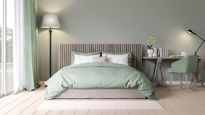Urban jungle in bedroom with double bed, lamp and carpet, real photo with copy space on the wall