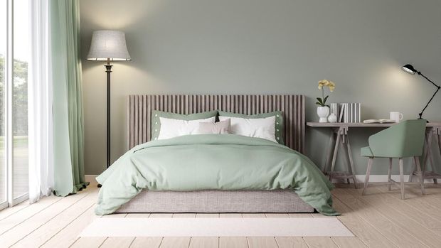Urban jungle in bedroom with double bed, lamp and carpet, real photo with copy space on the wall