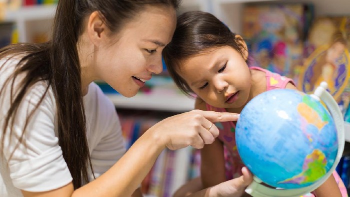 Ilustrasi ibu dan anak lihat globe atau peta
