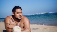 Sering jalan-jalan ke Bali, begini santainya Ivan Gunawan berjemur di atas pasir putih sambil menikmati sebuah kelapa hijau yang menyegarkan. Foto: Instagram @ivan_gunawan