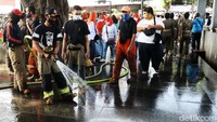Setelah bersih, jalur pedestarian langsung disemprot menggunakan air oleh petugas Diskar PB Kota Bandung.