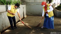 Sampah dan daun kering yang berserakan di jalur pedestarian Alun-alun Bandung disapu.