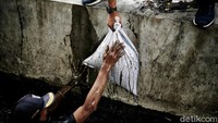 Tim gabungan harus nyemplung ke saluran air untuk mengangkat lumpur yang mengendap.