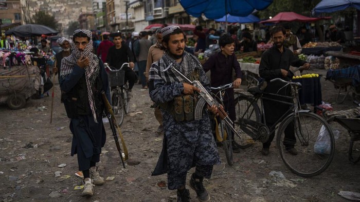 Warga Afghanistan Menjerit Kelaparan di Bawah Kekuasaan Taliban Afghans wait in front of a bank as they try to withdraw money in Kabul, Afghanistan, Sunday, Sept. 12, 2021. (AP Photo/Bernat Armangue)