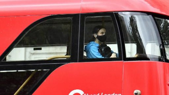 A passenger wears a face-mask as a Covid-19 protective measure as she travels on a bus in central London on July14, 2021. - London Mayor Sadiq Khan on Wednesday called for use of face coverings to remain compulsory on public transport in the British capital after government plans to relax Covid curbs begin on July 19. (Photo by JUSTIN TALLIS / AFP)