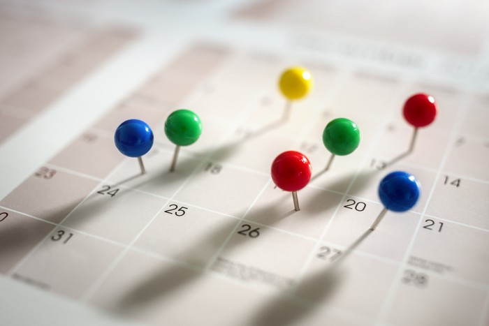 Thumbtack pins in calendar concept for busy, appointment and meeting reminder