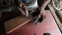 Eddy Roostopo tengah mengukut kayu untuk membuat busur dan anak panah.