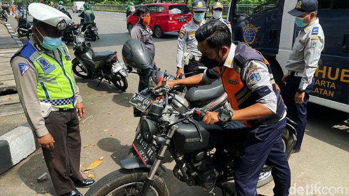 Dishub DKI Jakarta menggelar razia parkir liar di kawasan Kalibata, Jakarta. Sejumlah motor yang kedapatan parkir sembarangan dikempiskan bannya.