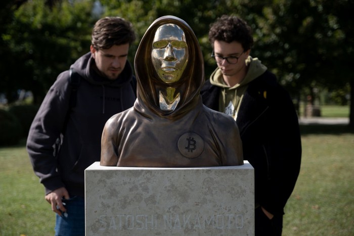BUDAPEST, HUNGARY - SEPTEMBER 22: Students take selfies of a statue of Satoshi Nakamoto, a presumed pseudonym used by the inventor of Bitcoin, as it is displayed in Graphisoft Park on September 22, 2021 in Budapest, Hungary. The statues creators, Reka Gergely and Tamas Gilly, used anonymized facial features, as Nakamotos true identify remains unconfirmed. (Photo by Janos Kummer/Getty Images)