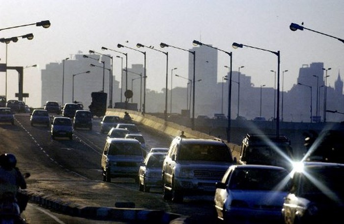 A picture taken 14 January 2004 shows traffic on an overpass advances on one of the newer bridges build in the commercial capital, with the skyline of Bombay in the background.  Union Finance Minister, Palaniappa Chidambaram during his Union Budget televised address 08 July 2004, announced there will be more impetus to growth in the infrastructure and road sectors. (Photo by ROB ELLIOTT / AFP)