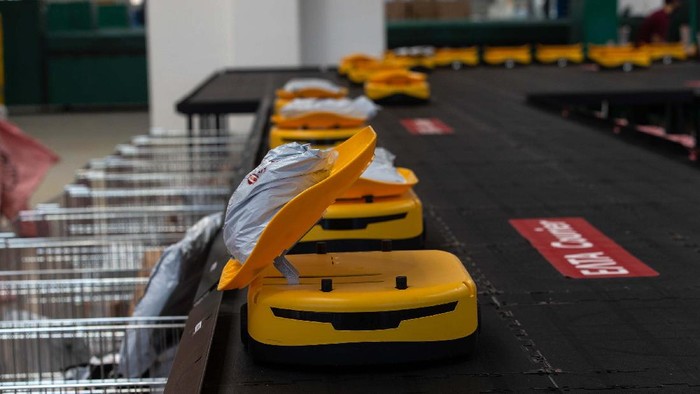 (210921) -- ATHENA, 21 September, 2021 (Xinhua) -- Para karyawan perusahaan penyedia layanan pos nasional Yunani, Hellenic Post (ELTA), bekerja dengan sistem robotik buatan China untuk menyortir barang kiriman di fasilitas milik ELTA di Kryoneri, wilayah pinggiran di sebelah utara Athena, Yunani, pada 14 September 2021. ELTA sudah mulai menggunakan sistem robotik buatan China untuk menyortir barang kiriman, menargetkan untuk mempercepat proses dan meningkatkan kualitas layanan bagi pelanggan. Sistem otomatis yang sepenuhnya terdigitalisasi itu dikembangkan oleh perusahaan China Zhejiang LiBiao Robot Co., Ltd. Sejak pertengahan Agustus, armada yang terdiri dari 55 robot mungil berwarna kuning ini telah bergabung dengan para karyawan di sejumlah fasilitas milik perusahaan layanan pos itu di Kryoneri. (Xinhua/Marios Lolos)